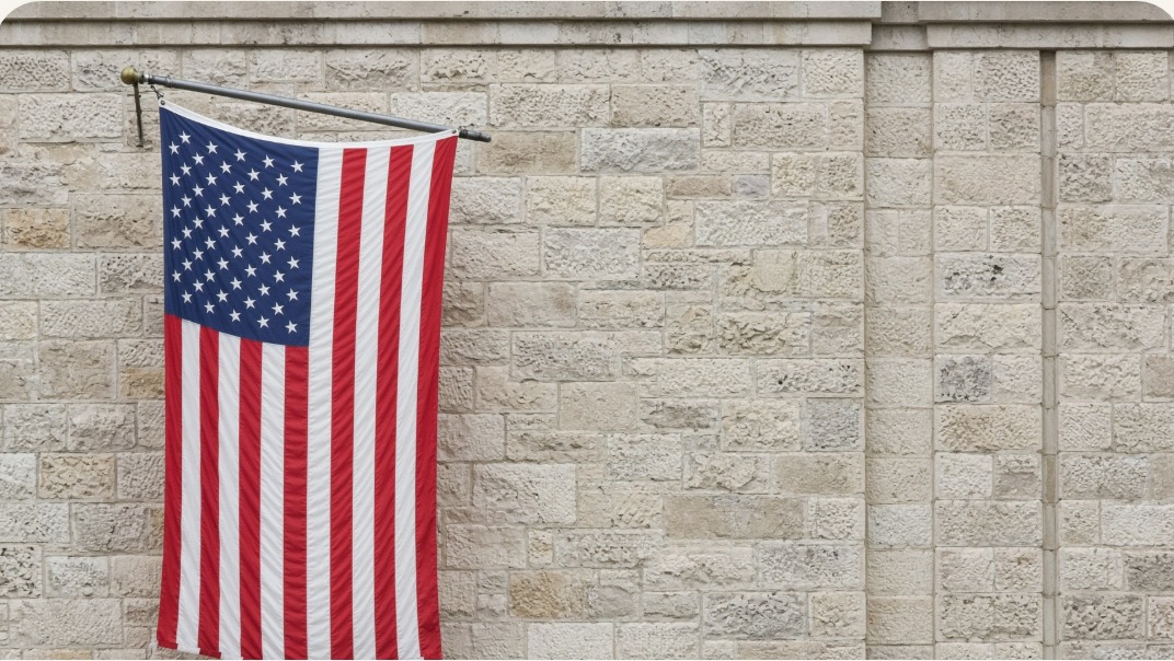American flag hanging on a limestone courthouse wall